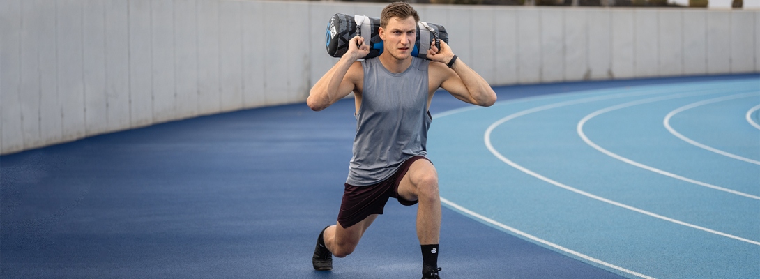 Runner with compression Ankle Support trains with dumbbells