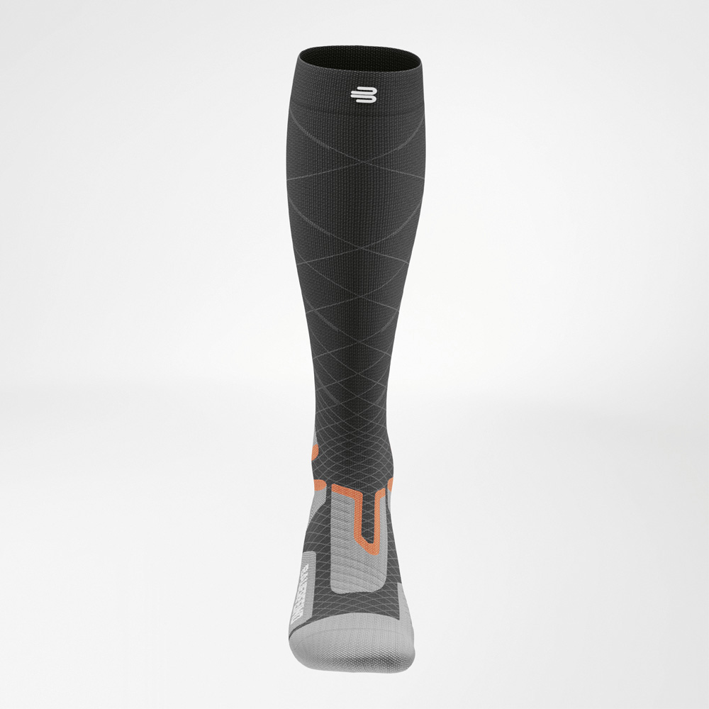 Ultimate control at top speed Front view of the Bauerfeind Sports Ski Performance sock. Fine lines highlight the progressive compression around the calf, with orange accents indicating zones of support and control.