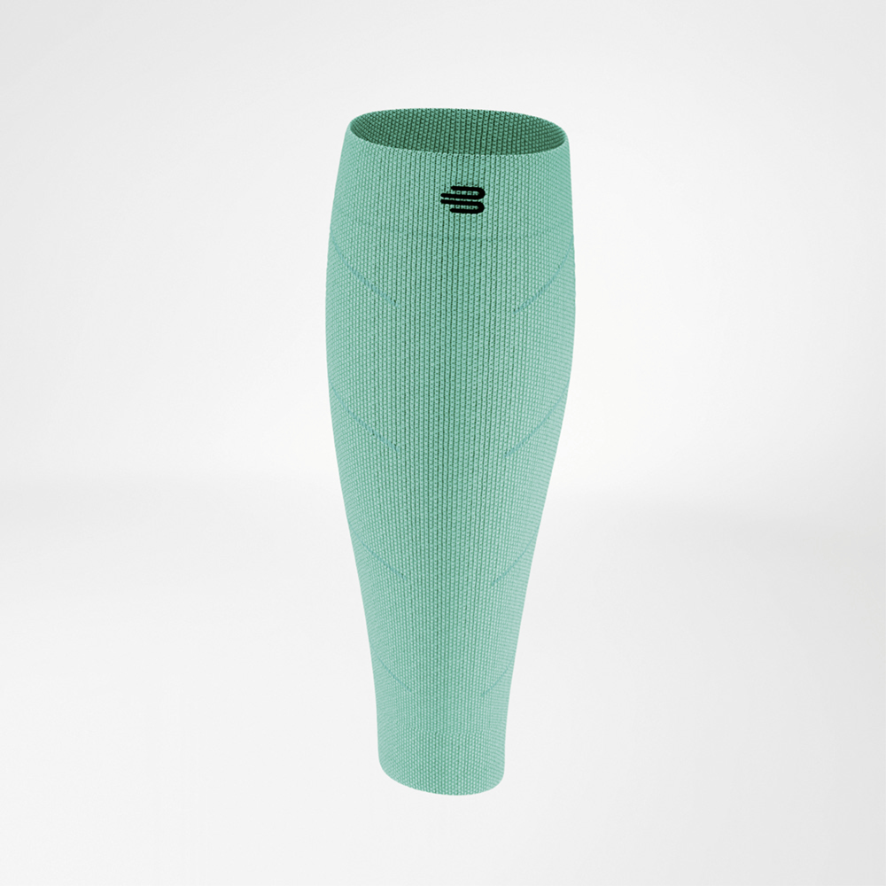 Compression sleeve in vibrant green, shown from the front. The elastic material closely fits the lower leg, with a black logo positioned above the center. The knit structure displays subtle diagonal lines for a dynamic look.