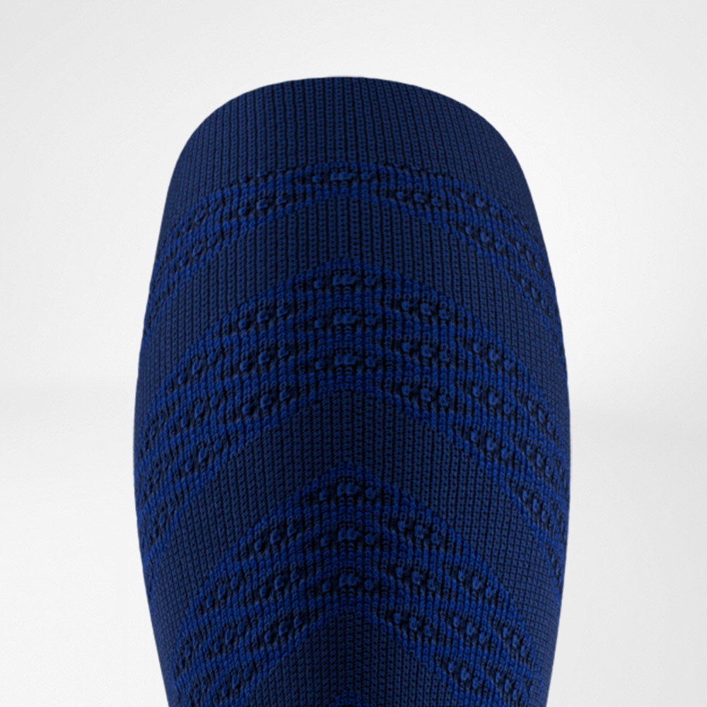 Close-up of a dark blue compression sleeve featuring a distinct V-shaped knit pattern. The tight fabric highlights the athletic design and functional support for the calf muscles.