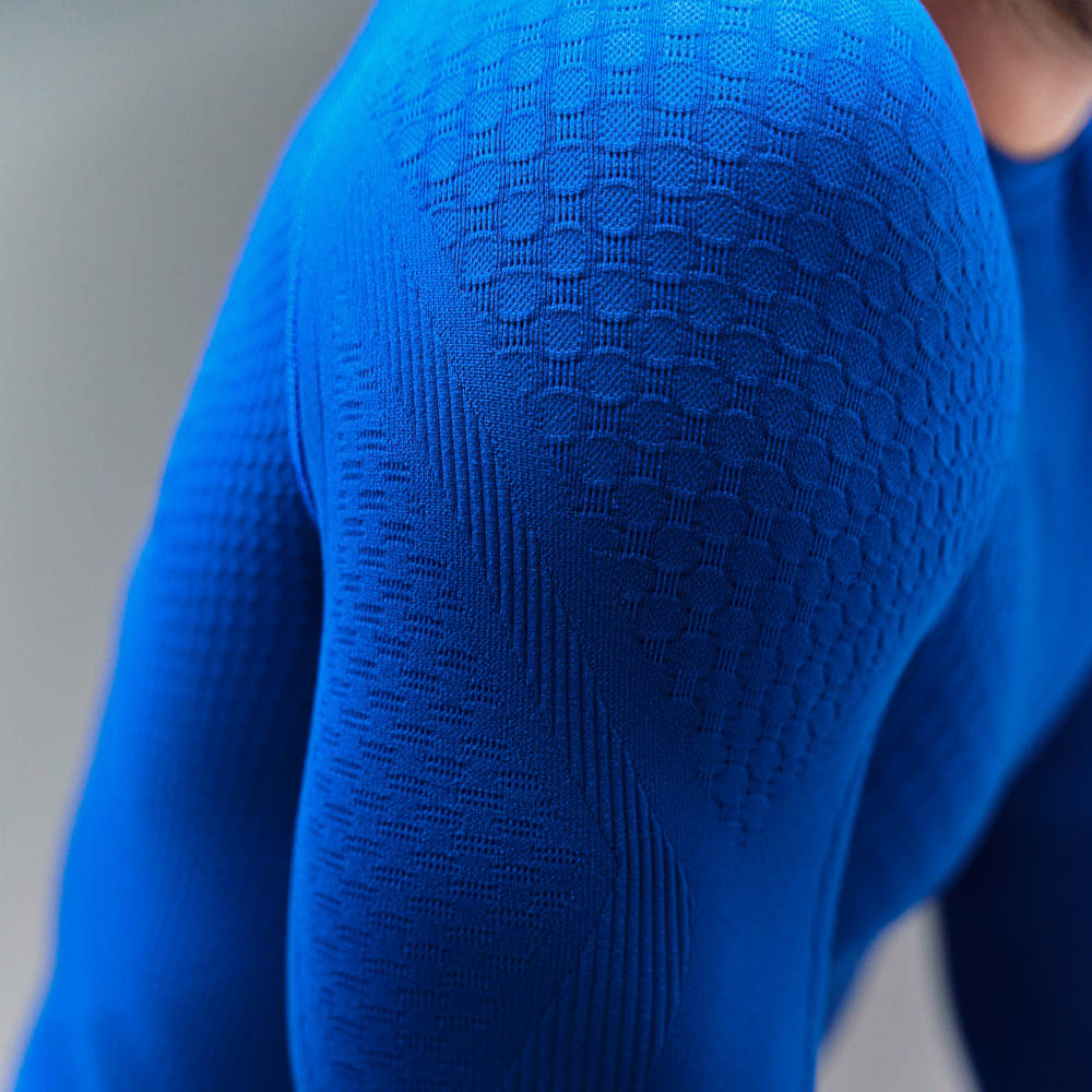 Sports top made from compression knit that emphasises the muscles Defined upper arm of a man wearing a long-sleeved blue compression top