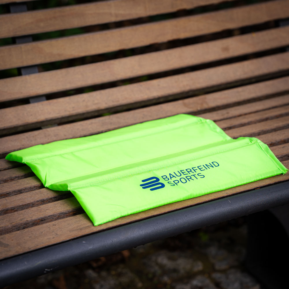 Unfolded Bauerfeind Sports seat cushion in bright green, ready for comfort.