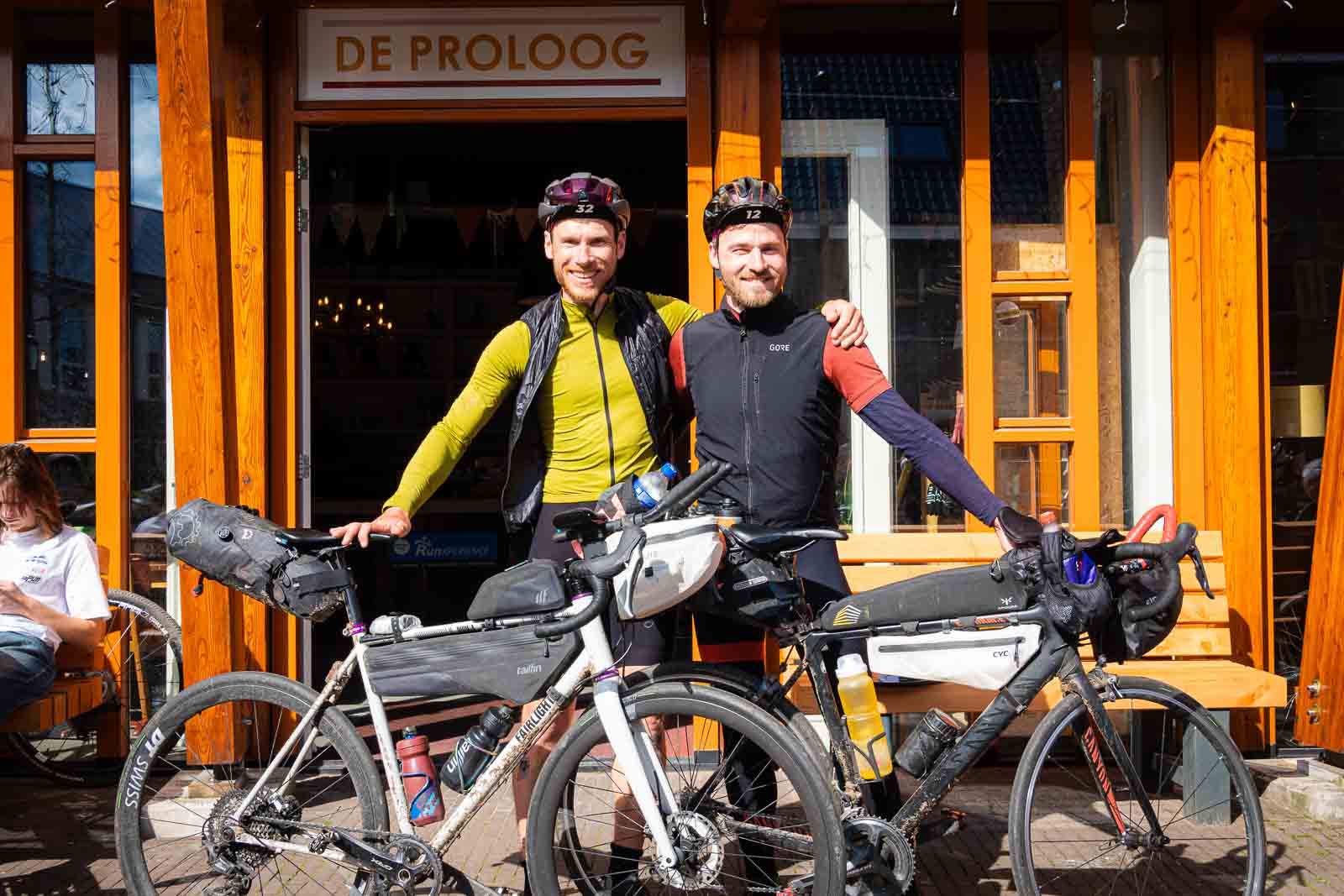 Two finishers stand in the finish area of the Race around the Netherlands and are happy.