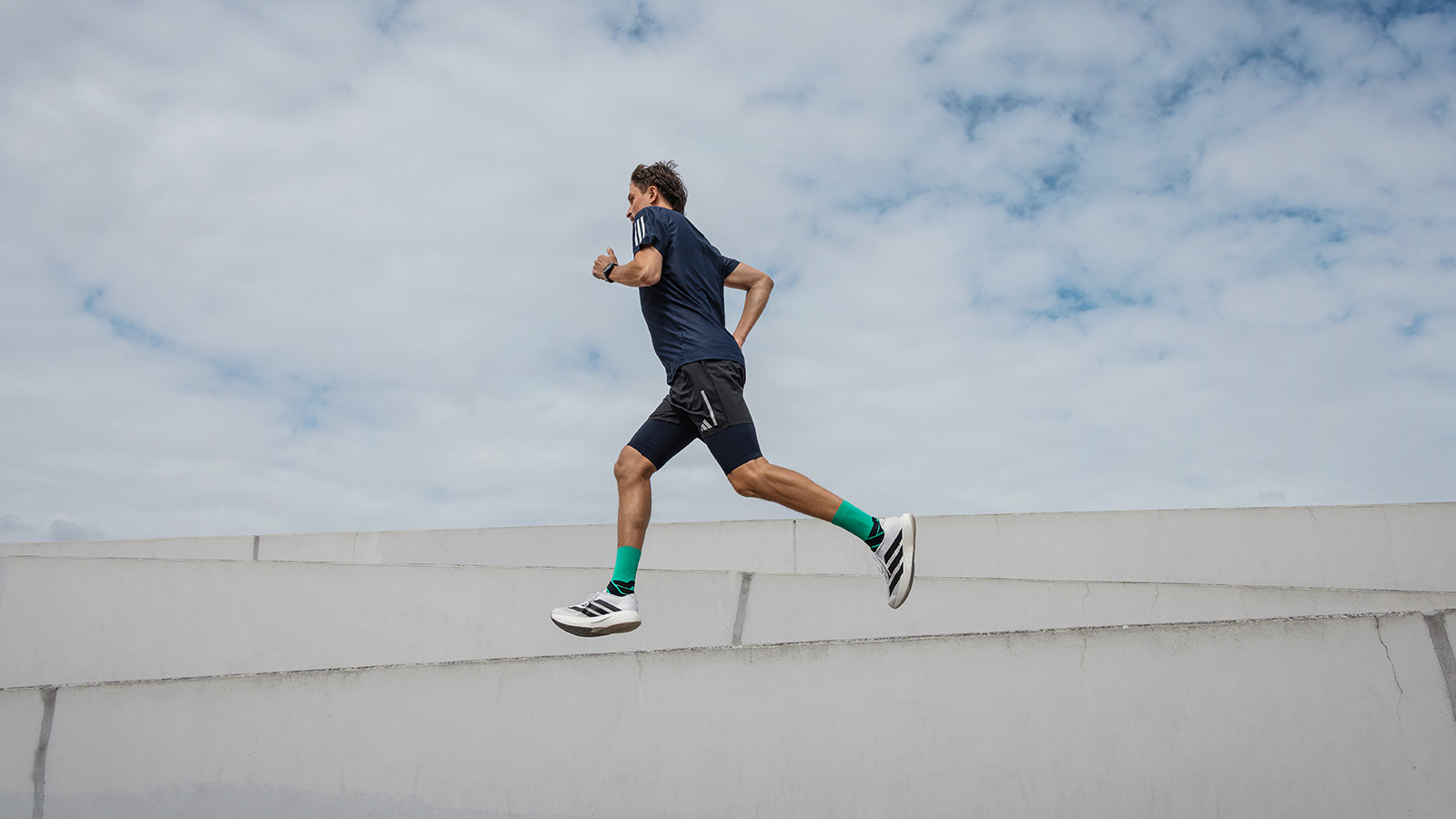 Man runs in a city next to a modern museum