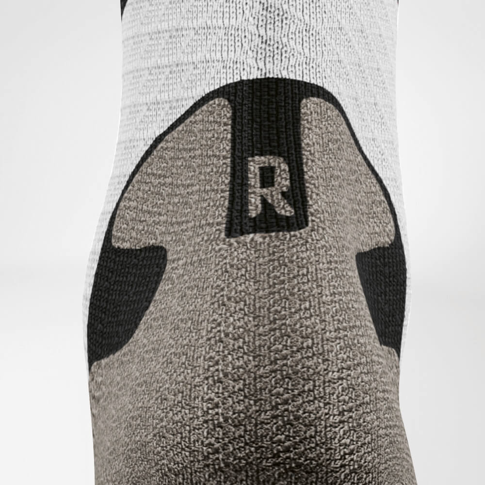 Detailed view of the Achilles' area of ​​the gray -white trail run - running socks
