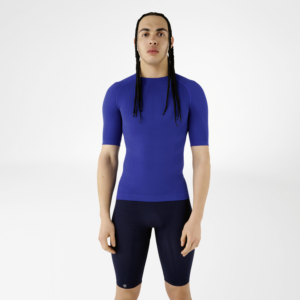 A man in blue compression wear standing upright and looking at the camera.