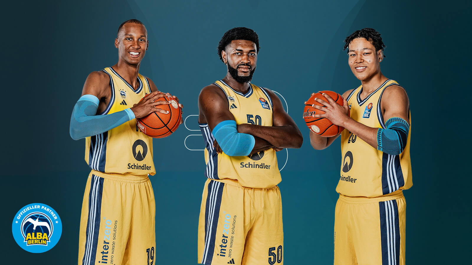Three basketball players from Alba Berlin stand in front of a blue background and look resolutely into the camera. Two of them have a ball in their hands and are holding it up, one is waving his arms.