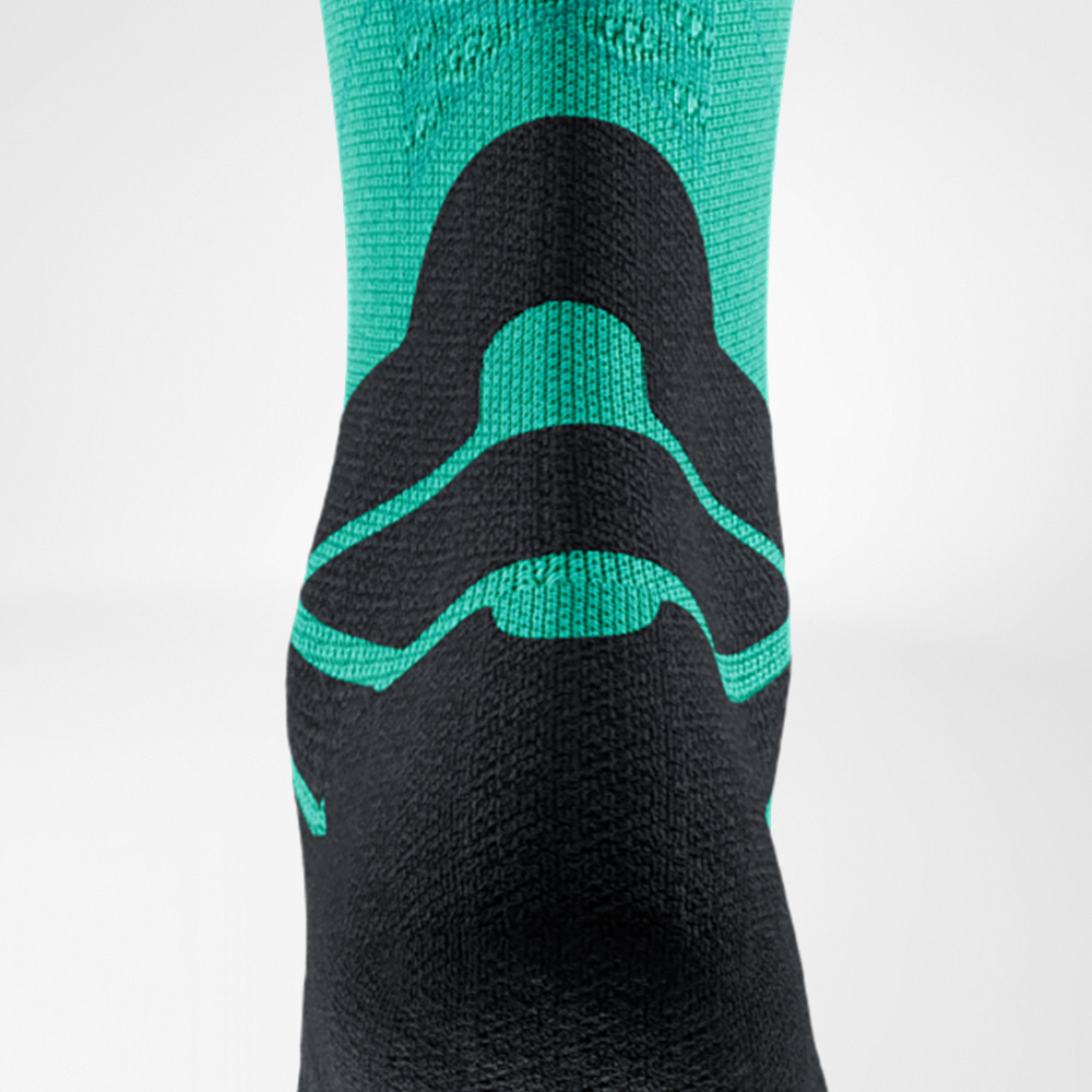 Back view of a mint green and black running sock by Bauerfeind Sports. The knitted padding sits right at the Achilles tendon for protection while running.