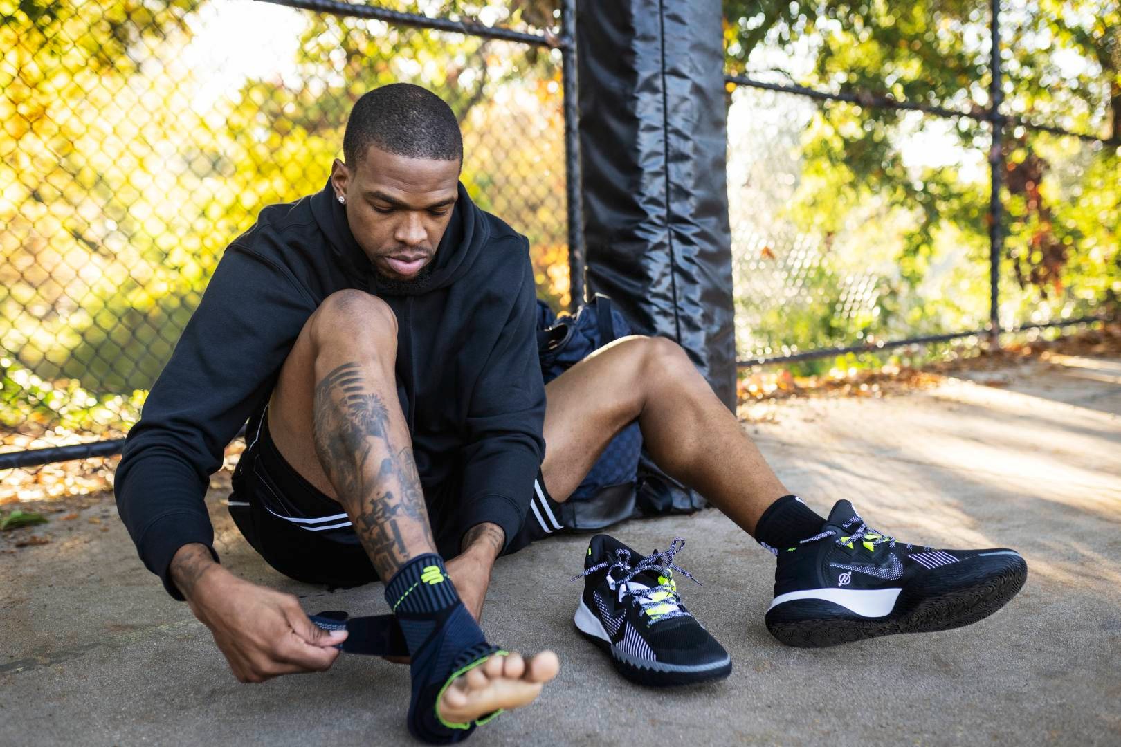 Basketball player with hoodie is on the edge of a streetball courts with a belt with a belt