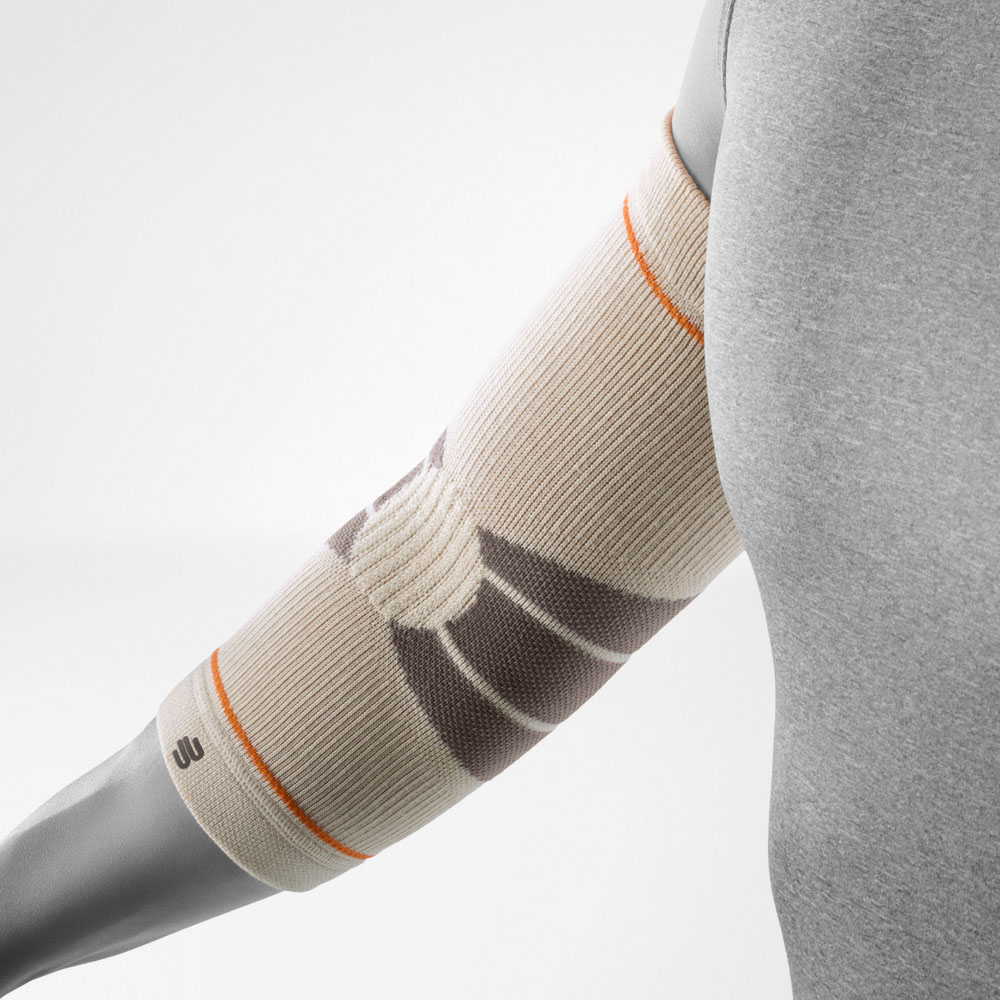 The Outdoor Compression Elbow Support in sandstone is shown on a bent arm. The elbow sleeve fits snugly around the joint and features a textured knit structure designed to provide targeted compression