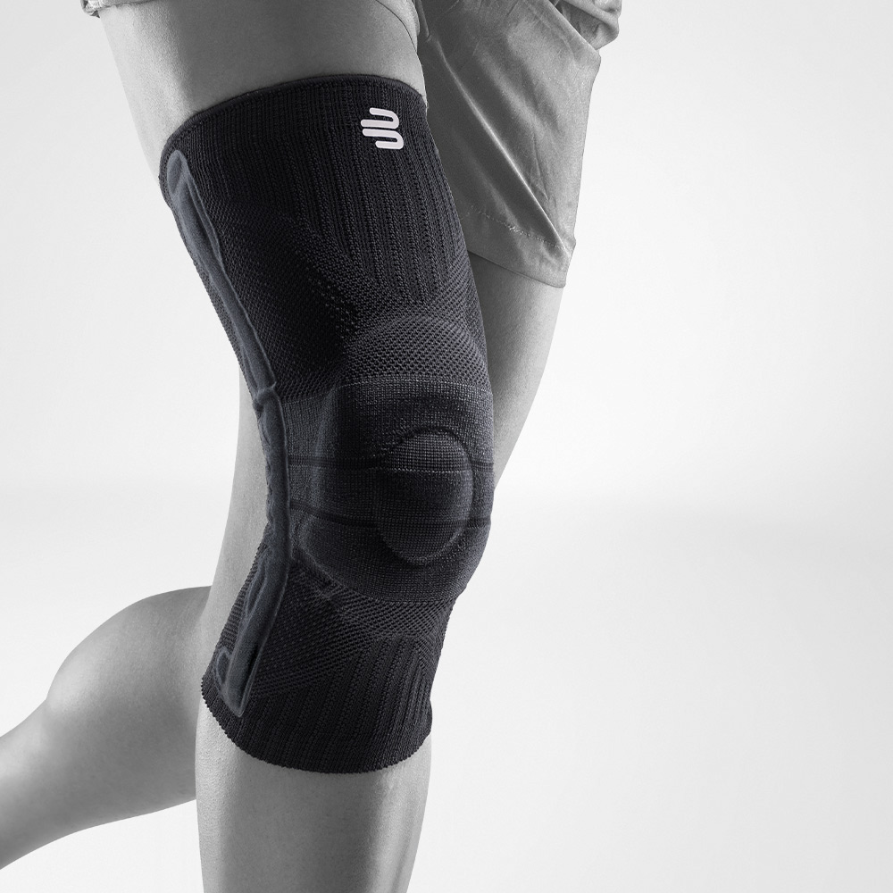 Knee support black front view diagonally Complete view of a black knee band for sport on the stylized gray leg