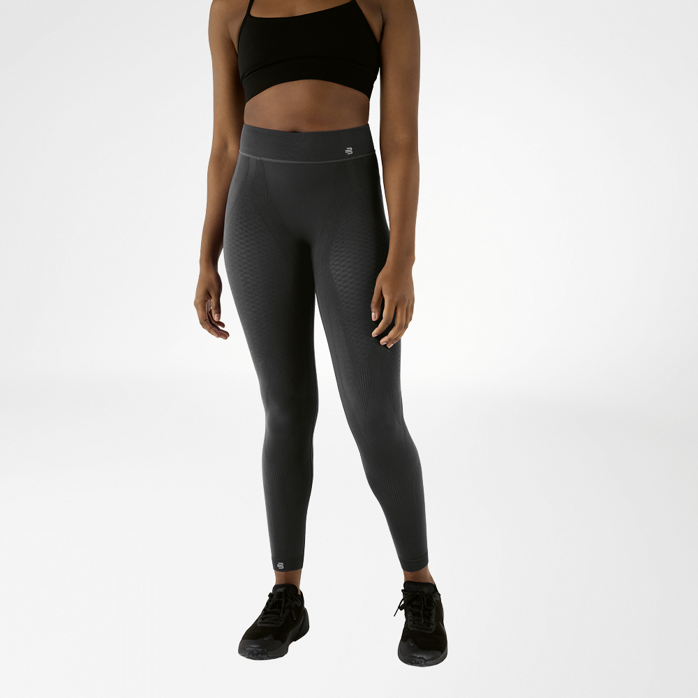 Sports outfit for women with anthracite-coloured, high-waisted compression tights Woman in black sports bra and anthracite-coloured ankle-length compression shorts