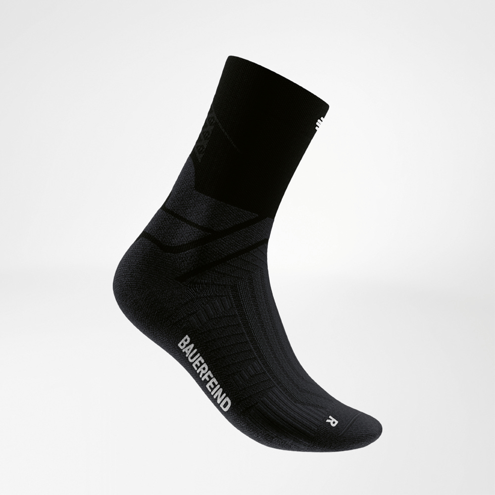 Side view of a black midcut running sock by Bauerfeind with contrasting logo and ergonomic fit. Designed for stability and grip during fast runs, combining performance with sleek style.