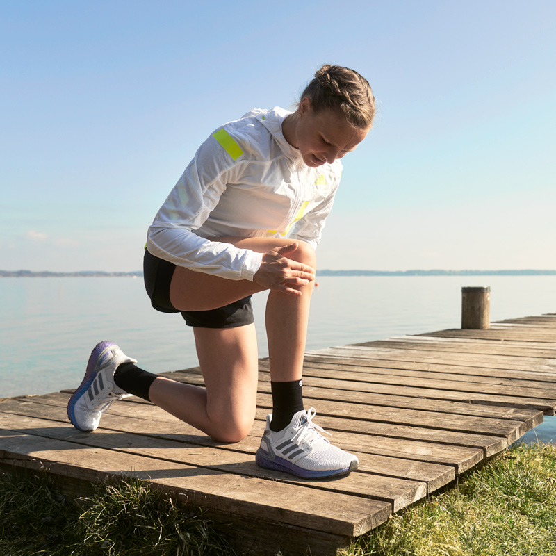 Langer Anna Hahner Kniend on the jetty holds her knee