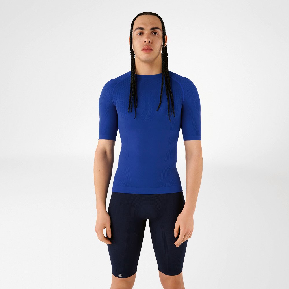 A man in blue compression wear standing upright and looking at the camera.