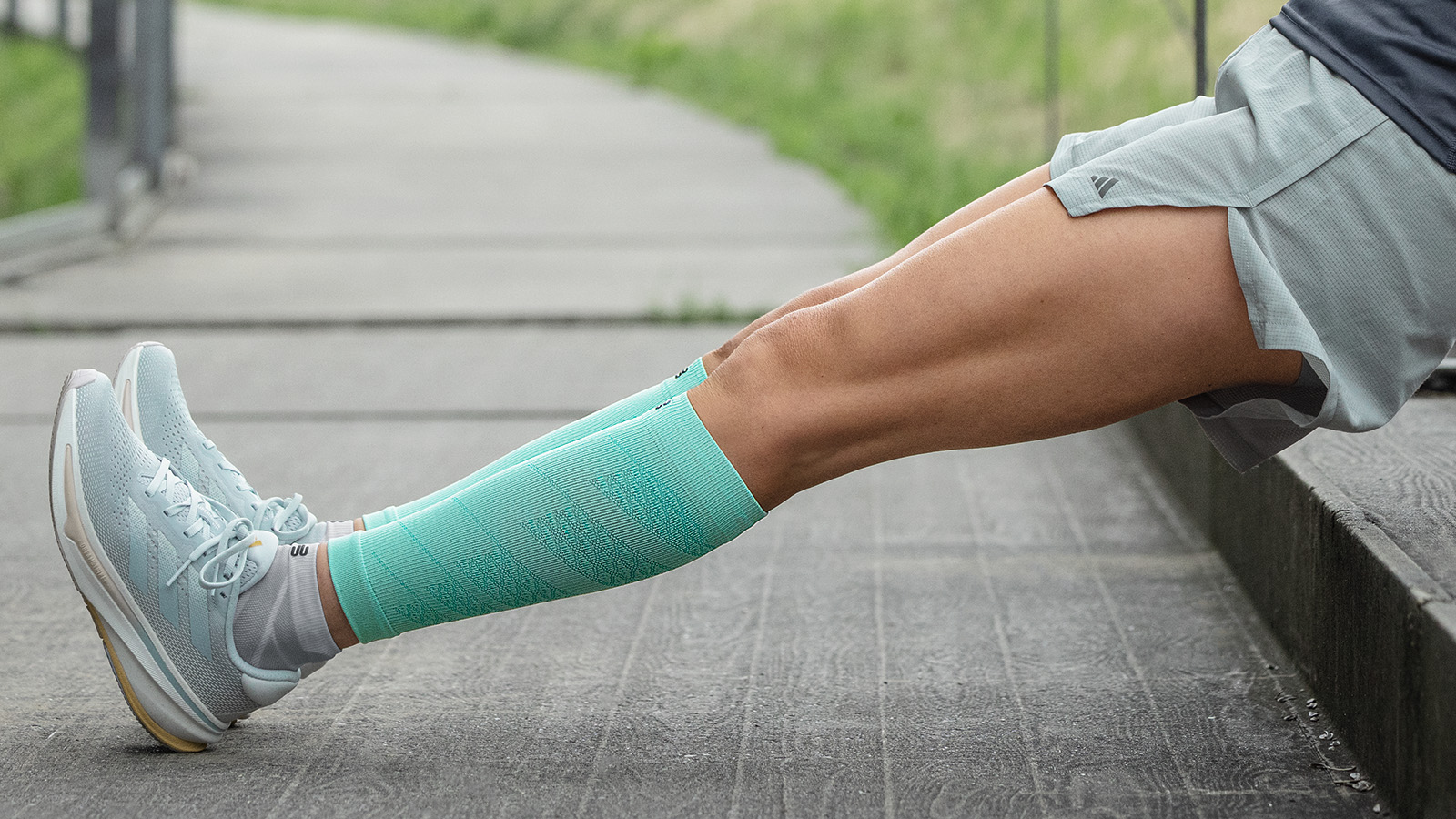 The runner stretches her calf with long running socks in pink