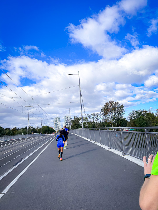 Runners on a bridge face strong headwinds without the help of a protective group during the half marathon.