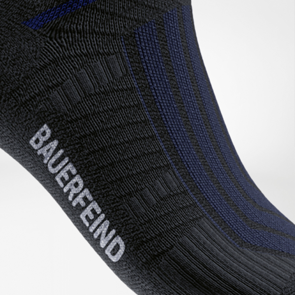 Side detail view of the black Run Performance Midcut Sock with subtle blue stripes and white “BAUERFEIND” lettering on the foot.
