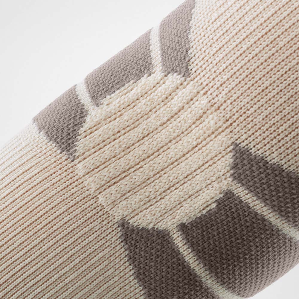 Close-up of the Outdoor Compression Elbow Support in sandstone. The fine knit texture and integrated compression zones highlight the functional material design, providing stability and comfortable wear during outdoor activities.