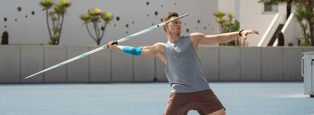 Ellenbogensleeve in the javelin throw Man trains javelin throw and wears a sports leeve for the elbow