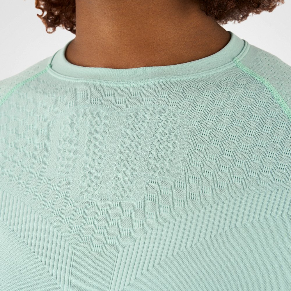 Close-up of a mint green compression shirt with textured fabric, highlighting the texture and details of the material.