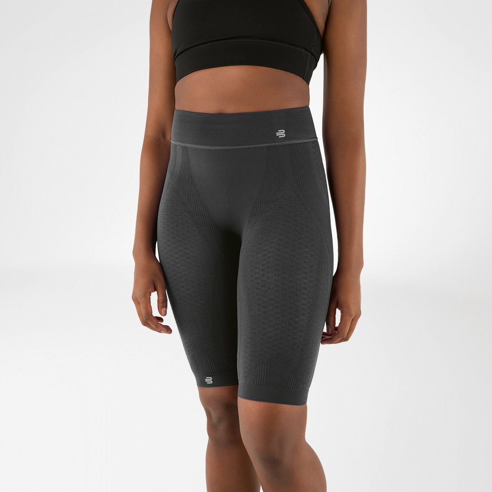 Lower body of a woman wearing knee-length, anthracite-coloured sports trousers