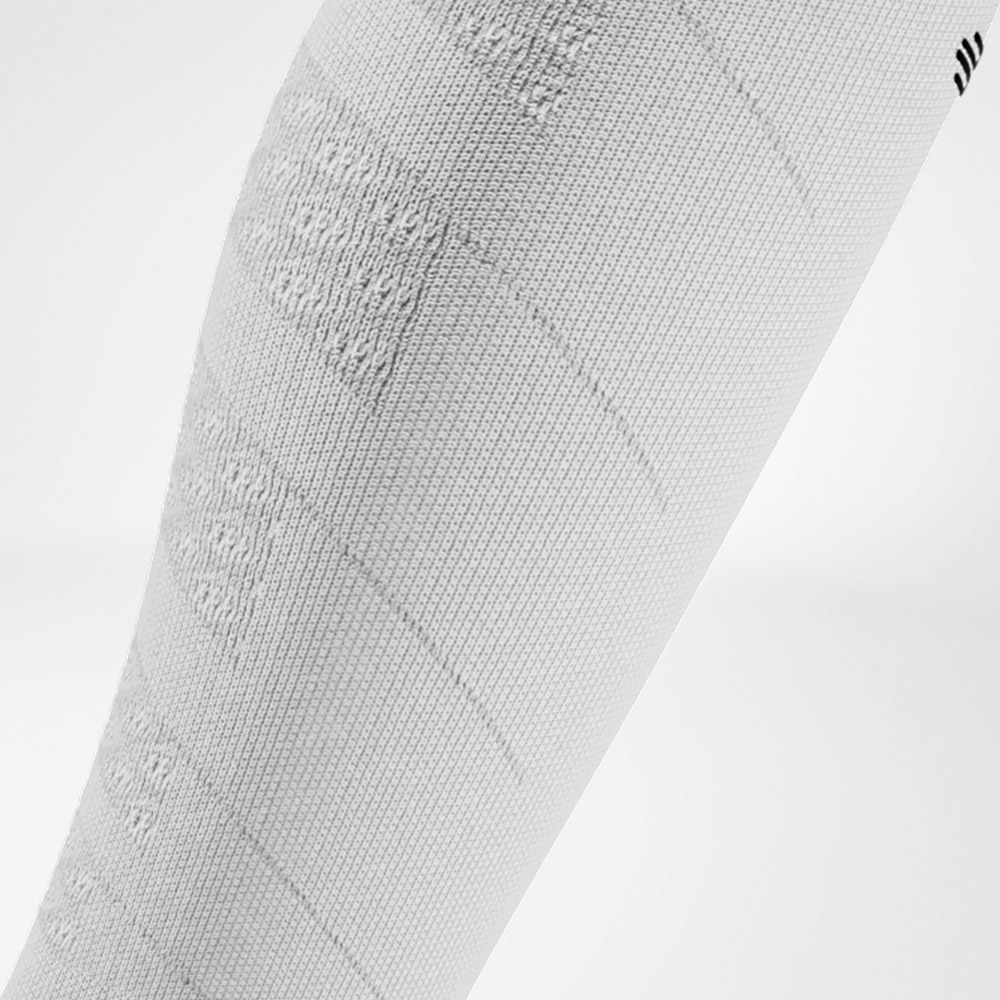 Close-up of a white compression sleeve with textured knit zones. A clean design that delivers both style and performance.