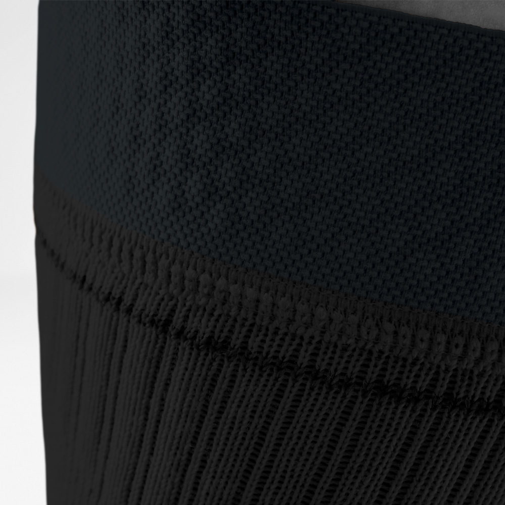 Close-up of the knitted upper edge of the black knee support, showing high-quality craftsmanship and breathable material.
