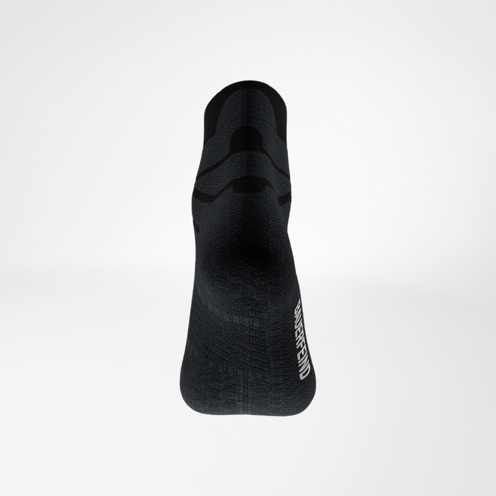 Rear view of the black Run Performance Low Cut Sock by Bauerfeind, heel in focus, fine knit texture and side logo visible.