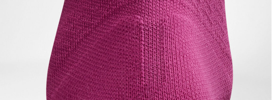 Detailed view on the Achilles tendon protection zone of the pink -colored airy knitted compression socks and running