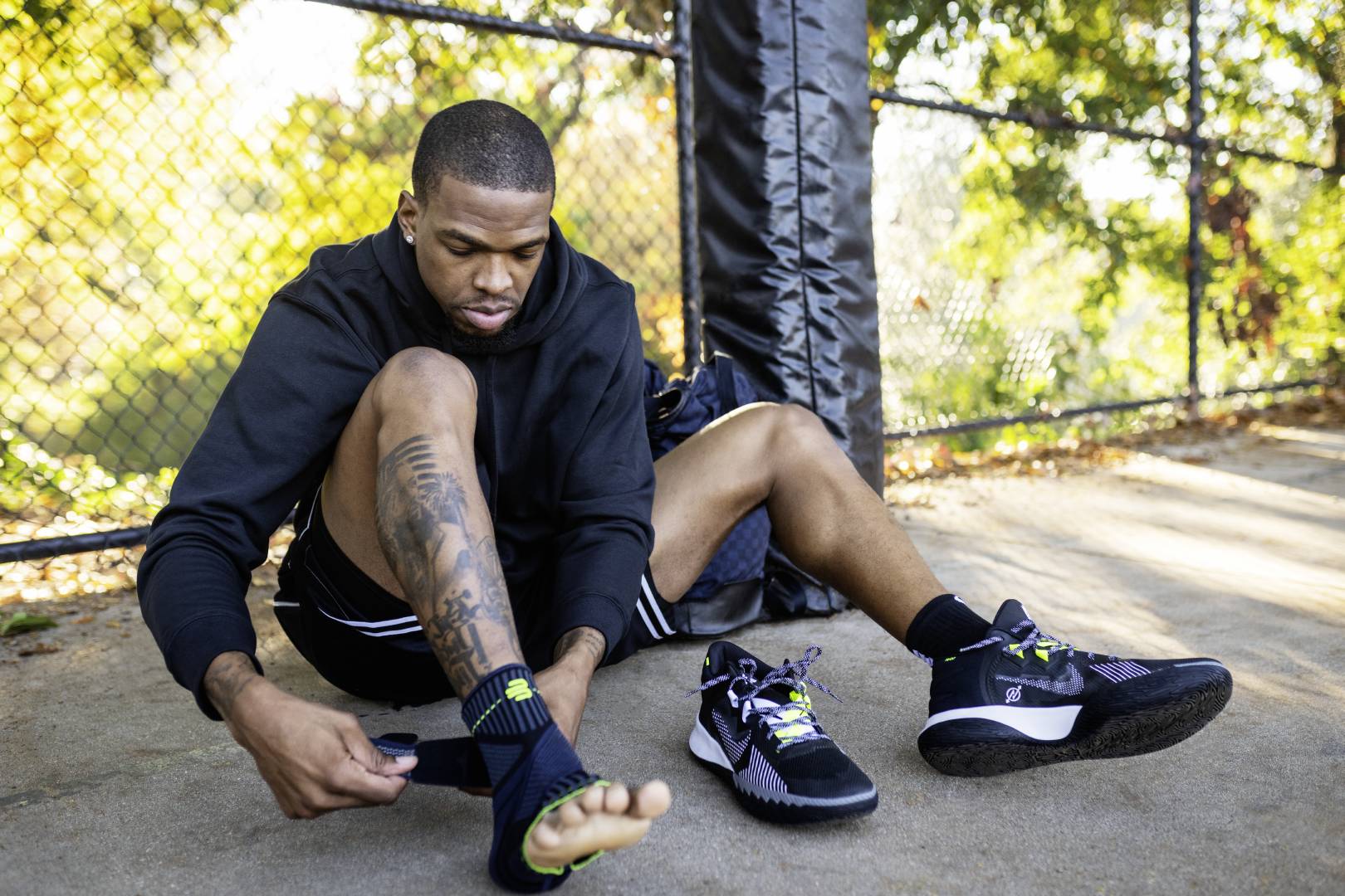 Basketball player with hoodie is on the edge of a streetball courts with a belt with a belt