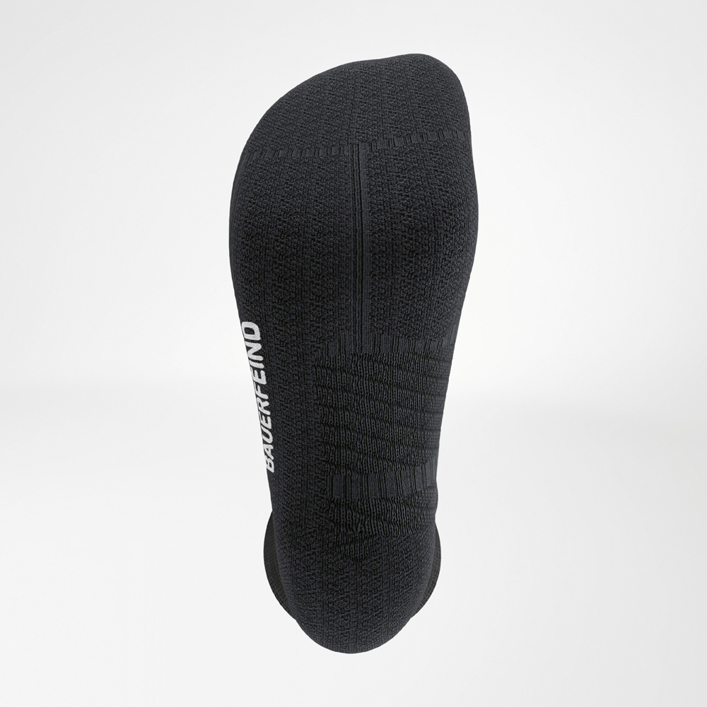 Close-up of the sole of a black running sock featuring cushioned structure, ergonomic seam design, and side BAUERFEIND branding.