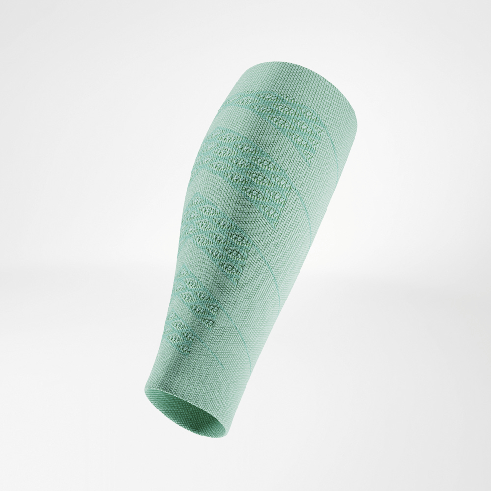 Close-up of a light green calf compression sleeve, displayed on a plain background. The seamless knit texture and small logo at the top are visible. The lightweight fabric looks breathable and provides targeted compression for running performance.