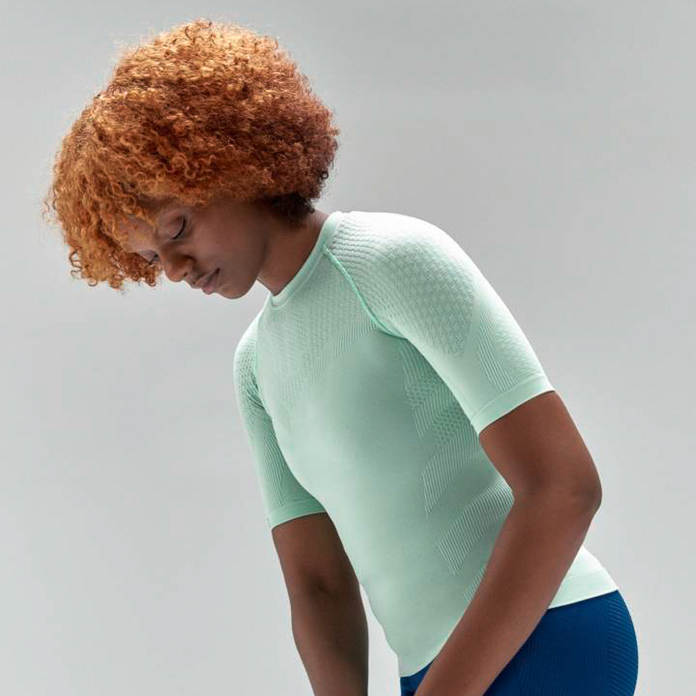 Mint green compression top for women Woman with red curls and mint green sports top stretches slightly