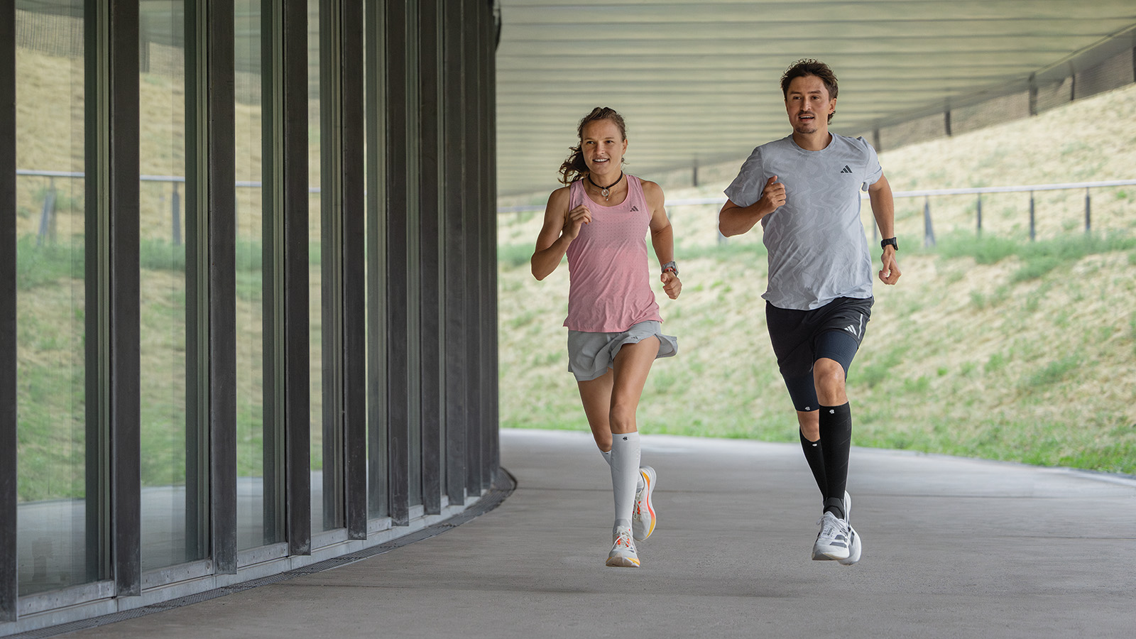 Langer with white-pink running socks runs next to a modern wall