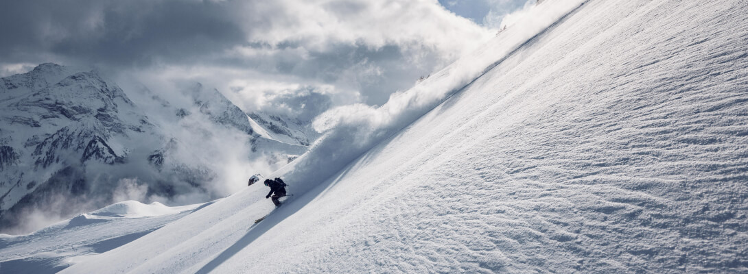 Skier on a steep piste during downhill skiing